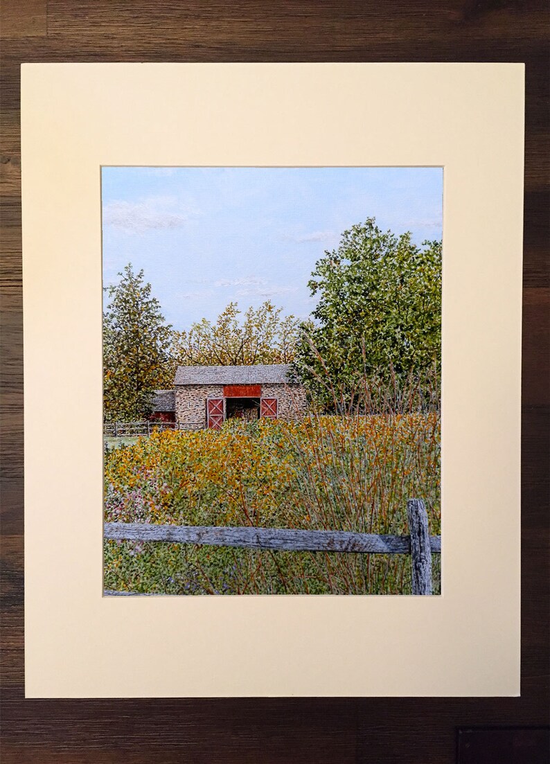 May include: A painting of a stone barn with red doors, surrounded by tall grass and trees. The barn is set against a blue sky with white clouds. A wooden fence is in the foreground.