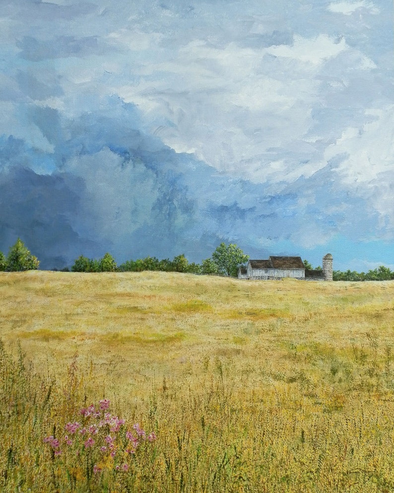 May include: A painting of a white farmhouse with a silo in a field of golden wheat. The sky is a stormy blue with white clouds.