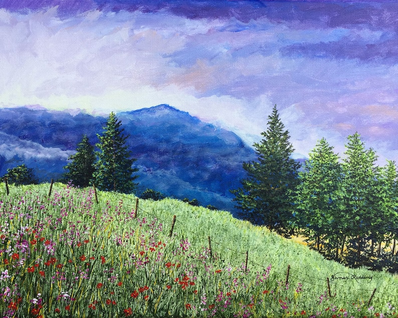 May include: A painting depicting a mountainous landscape with a field of wildflowers in the foreground. The sky is a vibrant purple with white clouds. There are several tall evergreen trees in the middle ground. The mountain is a deep blue colour.