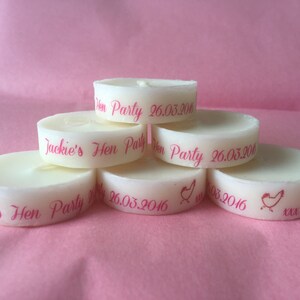K&ouml;nnte beinhalten: Ein Stapel aus sechs wei&szlig;en Teelichtern mit rosa Beschriftung. Die Kerzen sind mit dem Text "Jackie's Hen Party" und dem Datum "26.03.2016" verziert.
