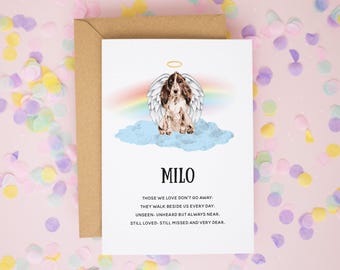 May include: A white greeting card with a brown envelope featuring an illustration of a brown and white spaniel dog with angel wings sitting on a blue cloud under a rainbow. The text reads MILO and a poem about love and loss.