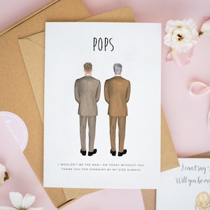 May include: A white greeting card featuring the text POPS at the top and an illustration of two figures in suits standing with their backs turned. Below the figures, the text reads: I WOULDN'T BE THE MAN I AM TODAY WITHOUT YOU. THANK YOU FOR STANDING BY MY SIDE ALWAYS.