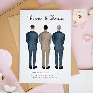 May include: A white greeting card featuring a watercolor illustration of three people standing with their backs to the viewer, wearing suits. The text reads "Thomas & Shaun" and "I NEED MY BROTHERS BY MY SIDE ON THE BIGGEST DAY OF MY LIFE! WILL YOU BE MY BEST MAN?"