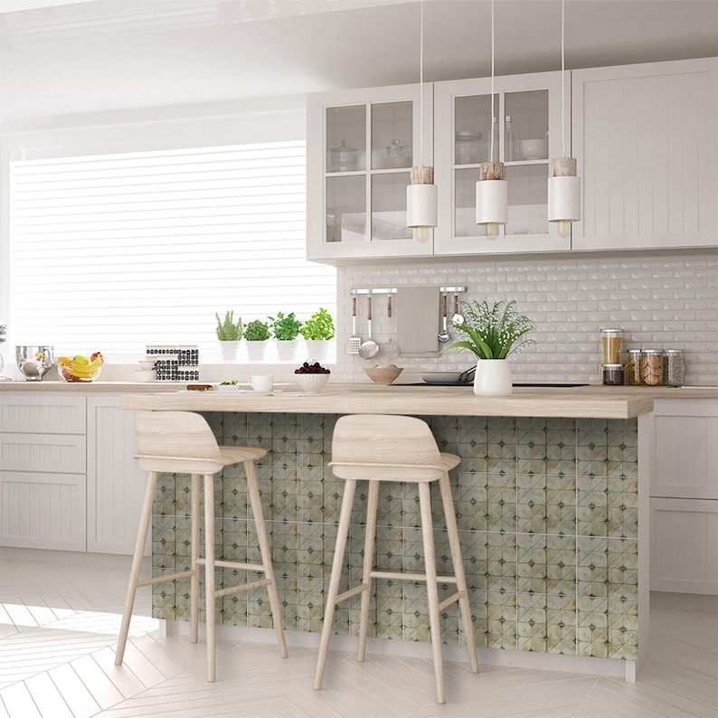 May include: A bright, modern kitchen with white cabinetry, a light wood countertop, and a patterned tile backsplash. Two wooden bar stools sit in front of a patterned tile island. Three pendant lights hang above the island.