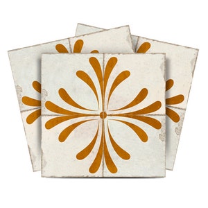 Pode incluir: Três azulejos de cerâmica branca com um padrão repetido de uma flor laranja estilizada.