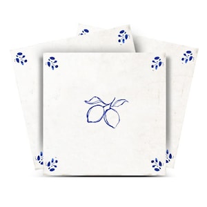 Puede incluir: Azulejos cuadrados blancos con una ilustración de limón azul y detalles florales en las esquinas. Los azulejos están dispuestos en forma de estrella, resaltando el diseño. La estética es limpia y minimalista, adecuada para la decoración de cocinas o baños.