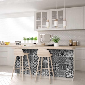 May include: A kitchen island with a wood countertop and two bar stools. The backsplash of the island is covered in black and white patterned tile.