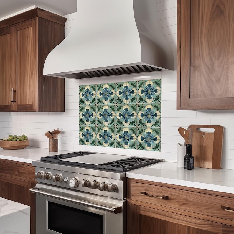 Puede incluir: Una campana extractora de acero inoxidable con una cubierta blanca y un salpicadero de azulejos con un patr&oacute;n floral azul y verde. El salpicadero est&aacute; hecho de azulejos de cer&aacute;mica con un acabado brillante.