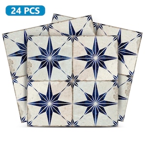Op de afbeelding: 24 stuks blauwe en witte stervormige tegel stickers. De stickers hebben een verweerde, vintage look.