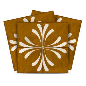 K&ouml;nnte beinhalten: Ein Satz von vier quadratischen Keramikfliesen mit einem wei&szlig;en floralen Design auf einem senfgelben Hintergrund.