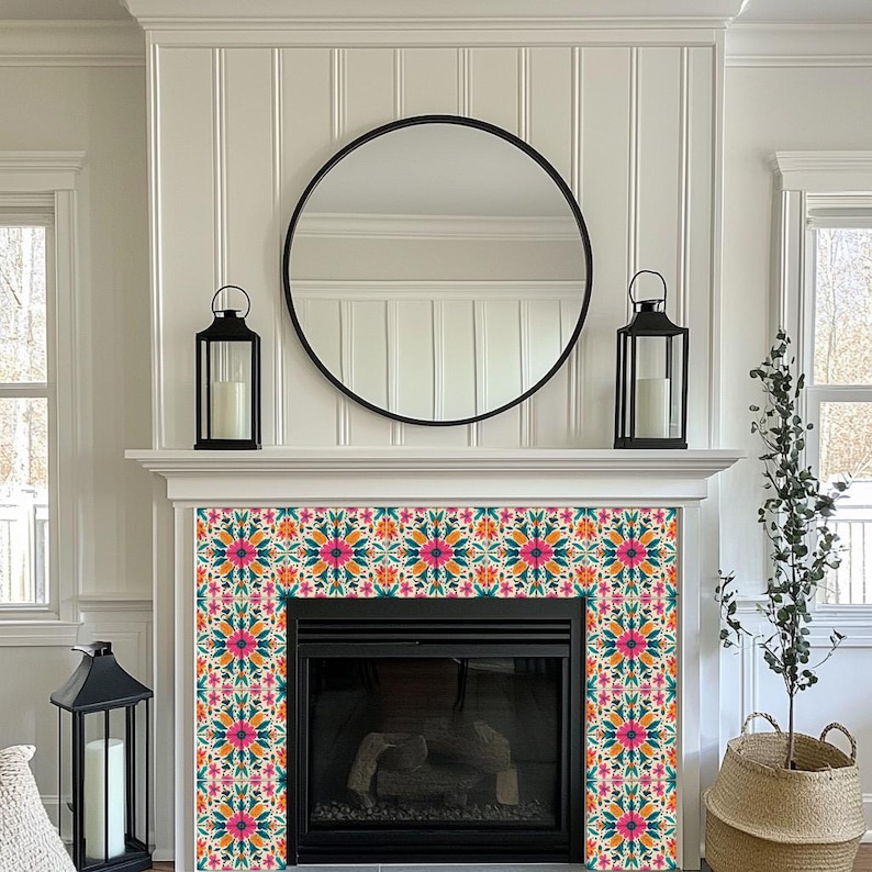 May include: A white fireplace mantel with a black mirror above it. The fireplace has a black surround and a black firebox. The mantel is decorated with a patterned tile surround in shades of pink, orange, teal, and white.