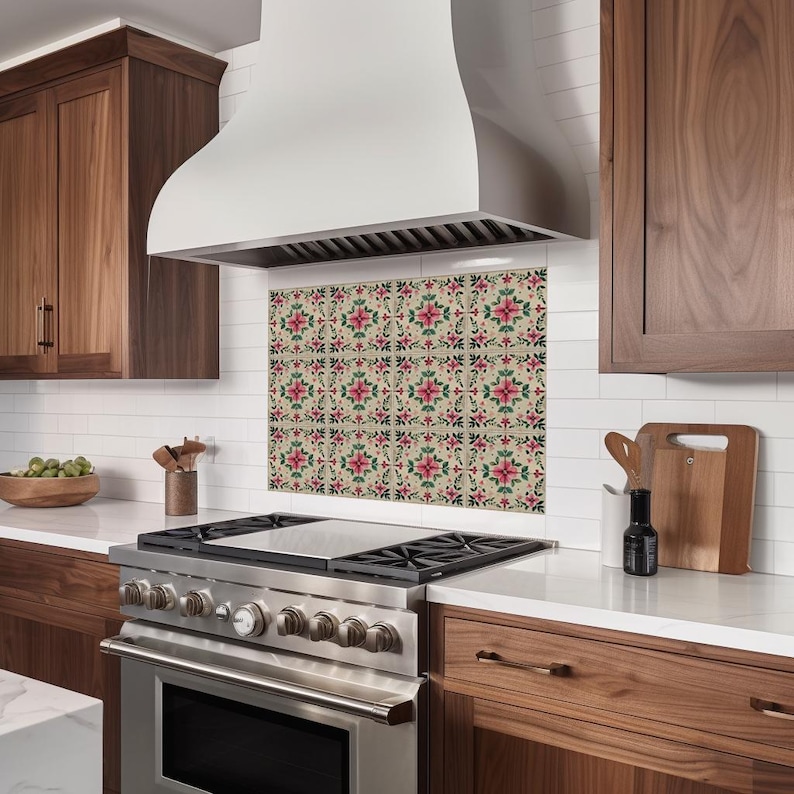 May include: A stainless steel range hood with a white canopy over a kitchen stove with a floral tile backsplash.