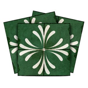 Op de afbeelding: Een set van vier groene keramische tegels met een wit bloemmotief. De tegels hebben een verweerde, vintage uitstraling.