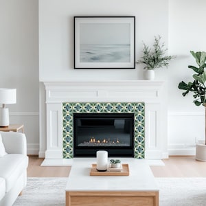 Puede incluir: Una chimenea blanca con una chimenea negra y un borde de azulejos decorativos en tonos azules y verdes. La chimenea est&aacute; encendida y hay una peque&ntilde;a planta en la repisa de la chimenea.