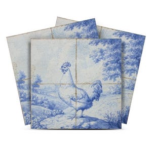 May include: Three blue and white ceramic tiles depicting a rooster in a landscape scene. The rooster is white with a red comb and wattle. The landscape is blue and white with trees and grass.