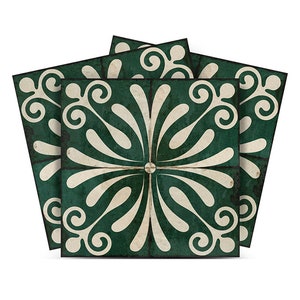 Może przedstawiać: Zestaw czterech zielonych i białych płytek ceramicznych z ozdobnym wzorem kwiatowym. Płytki mają postarzony, vintage'owy wygląd.