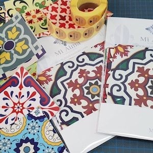 May include: A set of colorful tile stickers with a Moroccan design. The stickers are packaged in a white envelope with the text "Mi Alma" and a thank you sticker.