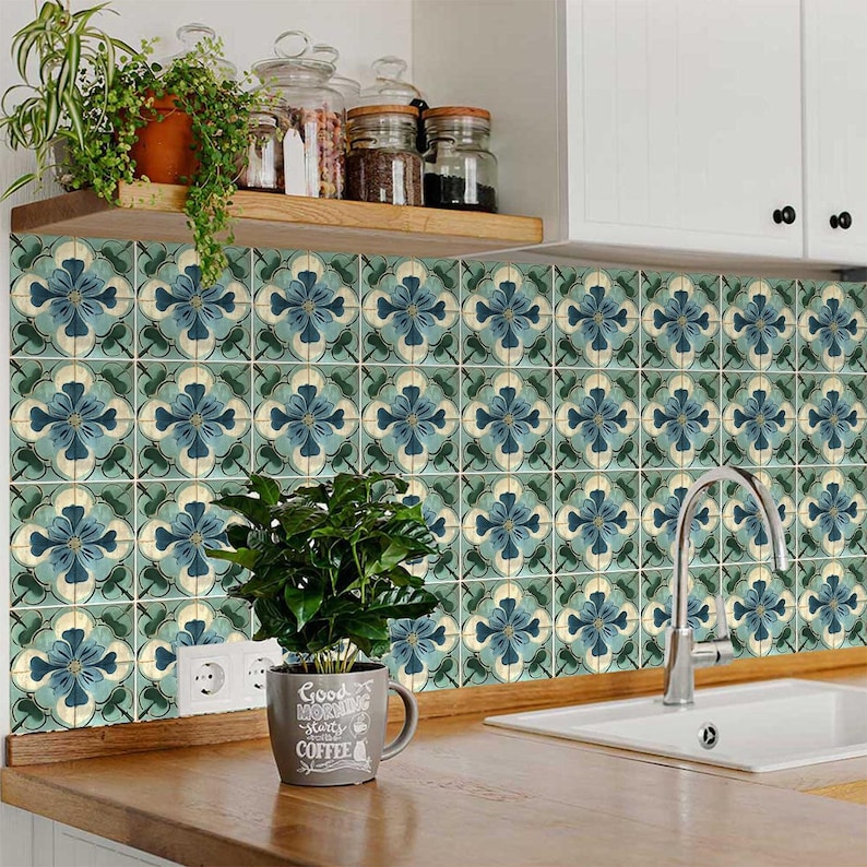 Puede incluir: Un salpicadero de cocina con azulejos de patr&oacute;n azul y verde. El azulejo tiene un dise&ntilde;o floral. Una taza de caf&eacute; con el texto "Good Morning starts with Coffee" est&aacute; sentada en el mostrador frente al salpicadero.