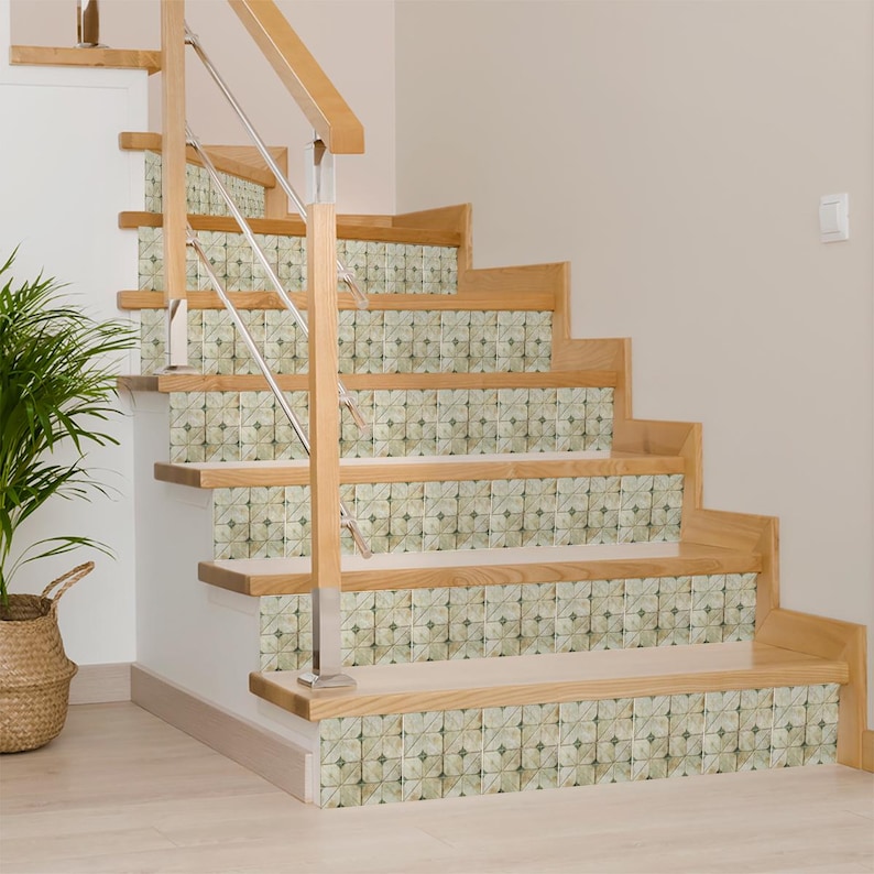 May include: Wooden staircase with decorative tile risers. The steps are made of light-colored wood, and the risers feature a repeating floral pattern in shades of green and beige. A stainless steel railing provides support.