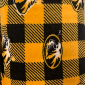 May include: Black and gold checked fabric with a repeated pattern of a tiger head logo.