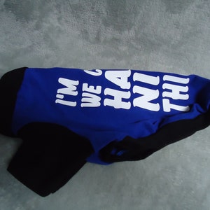 May include: A blue and black dog shirt with the text "I'm we go ha ni thi" printed in white.