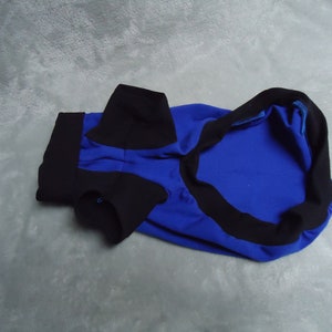 May include: A blue and black dog shirt with a collar and short sleeves.