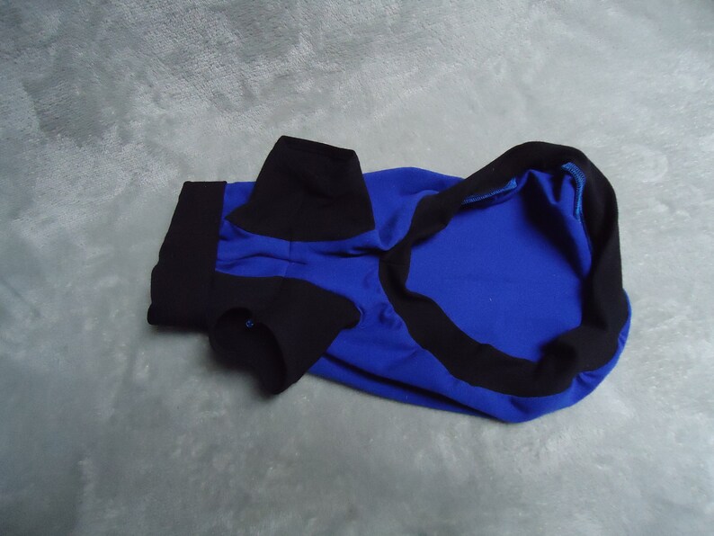 May include: A blue and black dog shirt with a collar and short sleeves.