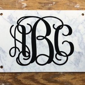 May include: White marble background with black monogram letters "ABC" in a cursive font.