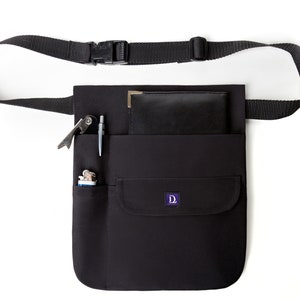 May include: Black canvas tool belt with a large pocket and several smaller pockets. The belt has an adjustable strap with a buckle. The belt is filled with various tools, including a lighter, a pen, and a multi-tool.