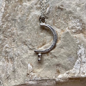 New moon pendant with symbolic seeds for intention setting
