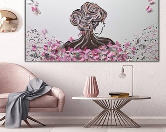 Può includere: Dipinto astratto con la silhouette di una donna circondata da farfalle rosa e bianche. Lo sfondo è una tela bianca con schizzi di vernice nera e bianca.