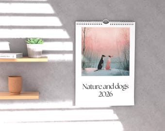 May include: A wall calendar with a nature scene featuring two dogs, one black and one pink, in a snowy landscape. The calendar is labeled "Nature and dogs 2026". The calendar is hanging on a gray wall.