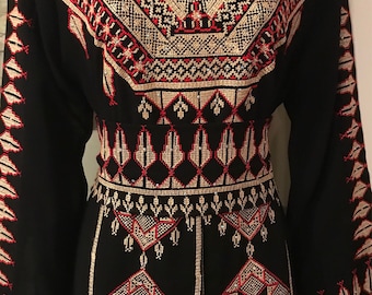 May include: A black long-sleeved dress with intricate gold and red embroidery. The embroidery features geometric patterns and floral motifs.