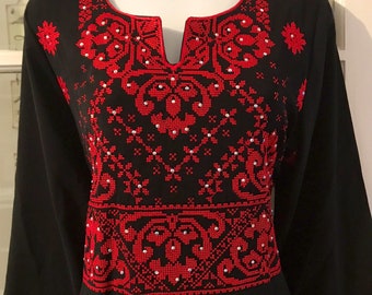 May include: Black long-sleeved dress with red embroidered floral patterns and white bead accents.