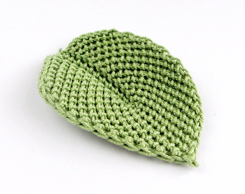Peut inclure: Un chapeau crochet&eacute; vert avec un design textur&eacute;.