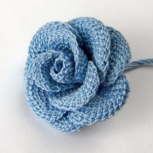 May include: A light blue crocheted rose flower with a single stem.
