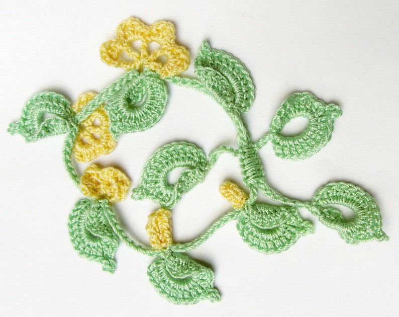 Puede incluir: Vid floral de ganchillo con flores amarillas y hojas verdes. La vid hecha a mano presenta costuras detalladas y un dise&ntilde;o calado delicado. Las hojas y las flores est&aacute;n en una disposici&oacute;n naturalista, perfecta para embellecer manualidades.