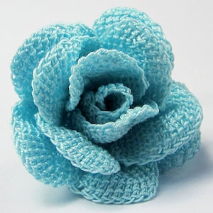 May include: A light blue crocheted rose flower.