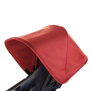 Könnte beinhalten: Ein rotes Kinderwagenverdeck mit einem großen, gebogenen Sonnenschutz.