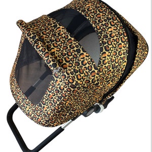 May include: A brown and black leopard print pet stroller with a black handle and a mesh window. The stroller has a black base with wheels.