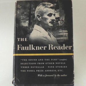 May include: A vintage hardcover book titled "The Faulkner Reader." The cover features a black and white portrait of a man and the title in white lettering. Additional text includes selections from novels and stories.