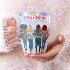 May include: White ceramic mug with a winter scene featuring four women wearing colorful sweaters and jeans. The text "Merry Christmas" is at the top of the mug. The names "Maria, Anna, Sarah, and Hila" are written at the bottom of the mug.
