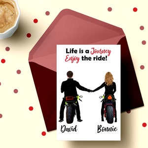 Pu&ograve; includere: Un biglietto bianco con il testo "Life is a Journey Enjoy the ride!" e due silhouette di persone che guidano motociclette. Il testo "David" &egrave; sotto la prima silhouette e "Bonnie" &egrave; sotto la seconda silhouette.