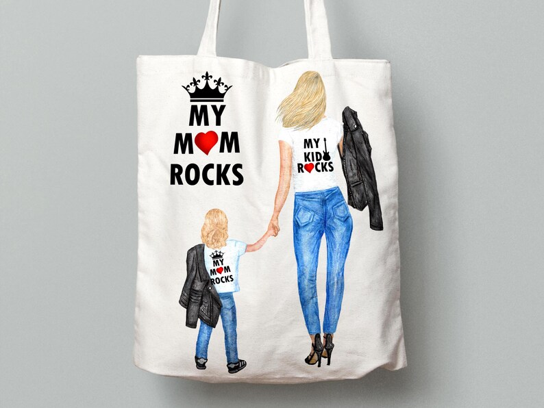 Op de afbeelding: Witte tote bag met een zwarte kroon en de tekst "My Mom Rocks" aan de ene kant en een vrouw en kind die witte shirts dragen met de tekst "My Kid Rocks" aan de andere kant.