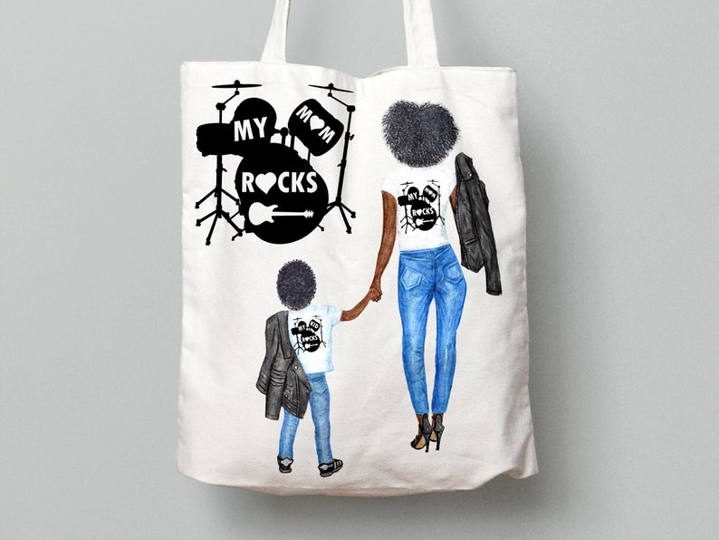 Op de afbeelding: Een witte tote bag met een zwart-witte illustratie van een moeder en haar zoon. De moeder draagt een wit T-shirt met de tekst "My Mom Rocks" en een zwart leren jack. De zoon draagt een wit T-shirt met de tekst "My Mom Rocks" en een zwart leren jack. De tas heeft ook een zwart-witte illustratie van een drumstel met de tekst "My Mom Rocks".