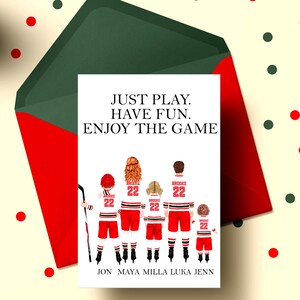 May include: A white card with a red and white hockey player illustration. The text on the card reads "JUST PLAY. HAVE FUN. ENJOY THE GAME". Below the illustration are the names "JON MAYA MILLA LUKA JENN".