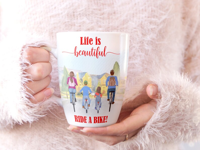 May include: White ceramic mug featuring a watercolor illustration of a family riding bikes. The mug has the text "Life is beautiful" in red script above the illustration and "RIDE A BIKE!" in red block letters below.