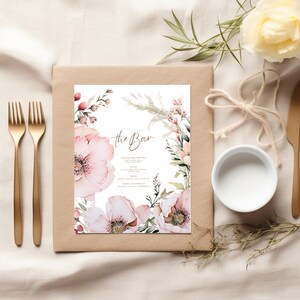 May include: A printable wedding bar menu with a floral design. The menu features a watercolor illustration of pink flowers and greenery. The text "the Bar" is written in gold script at the top of the menu.