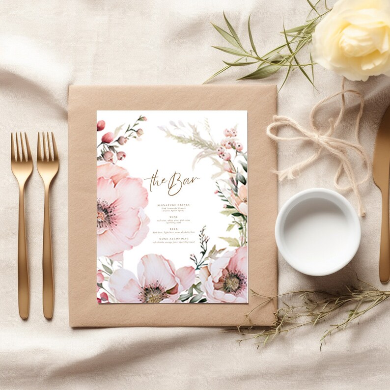 May include: A printable wedding bar menu with a floral design. The menu features a watercolor illustration of pink flowers and greenery. The text "the Bar" is written in gold script at the top of the menu.