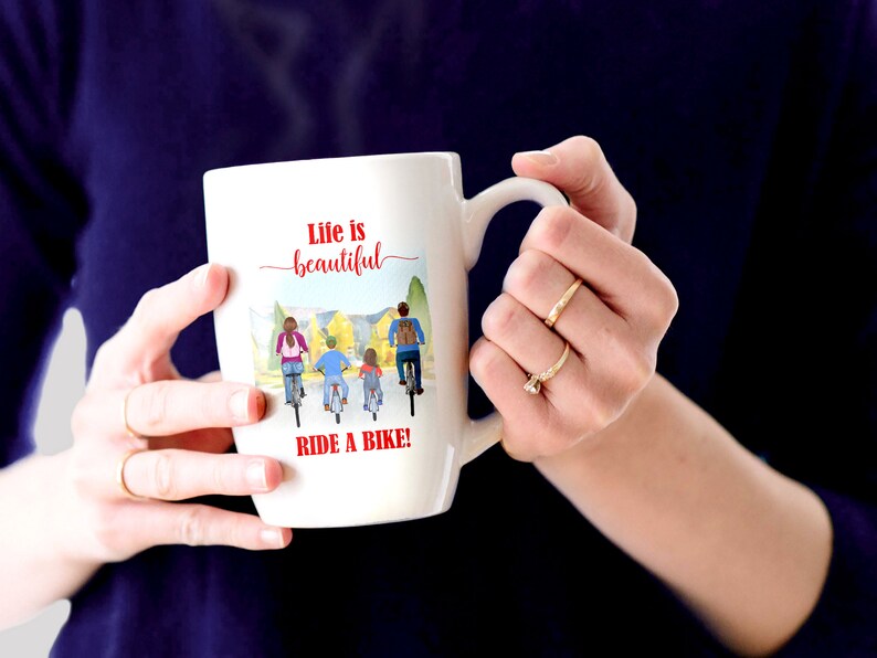 May include: White ceramic mug with a handle, featuring the text "Life is beautiful" in red script above a watercolor illustration of a family riding bikes. The phrase "RIDE A BIKE!" is printed in red below the illustration.